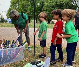 Image of kids waiting in line for free sporting equipment or tennis rackets. 